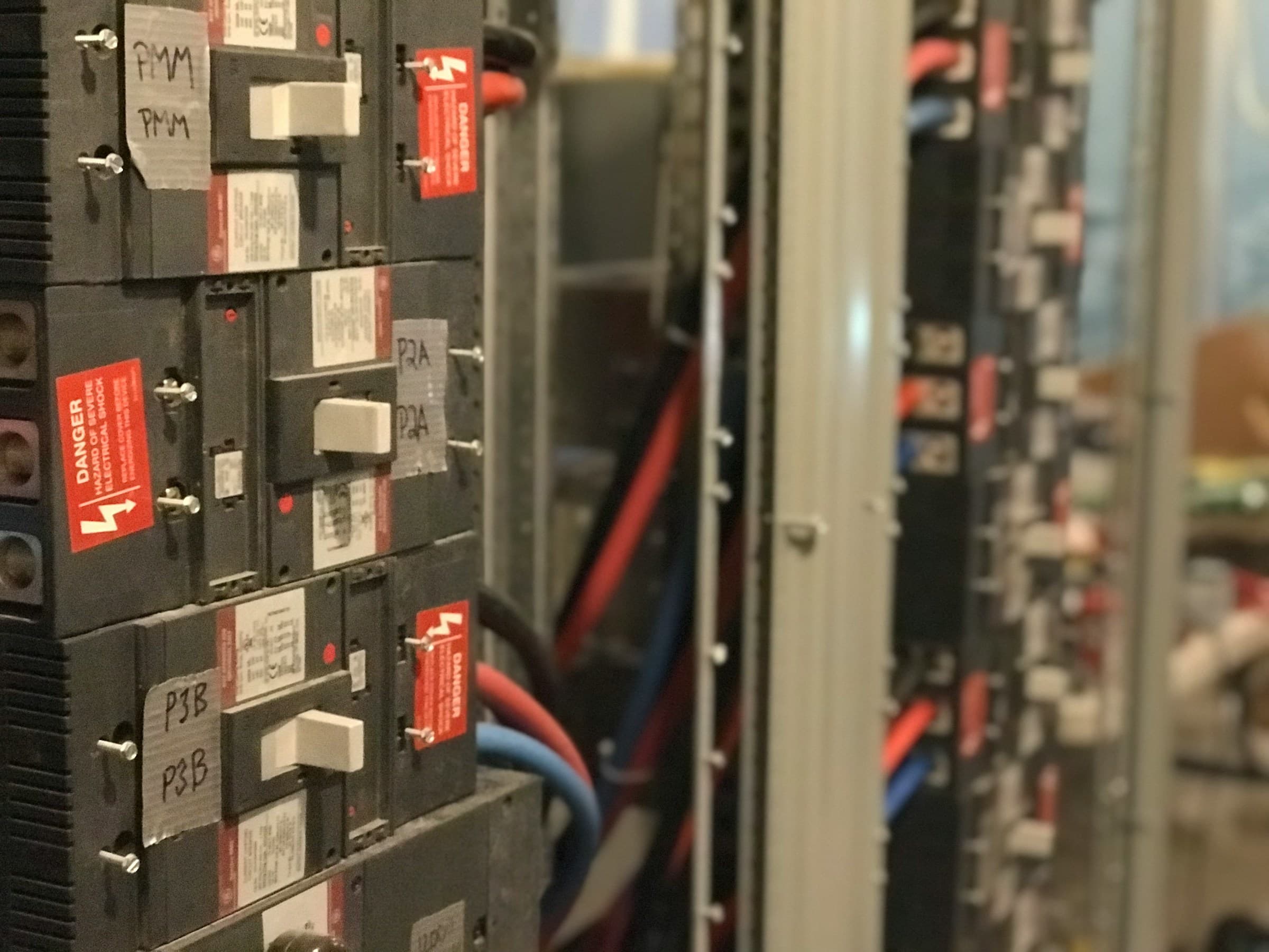 Professional electrician inspecting commercial electrical panel